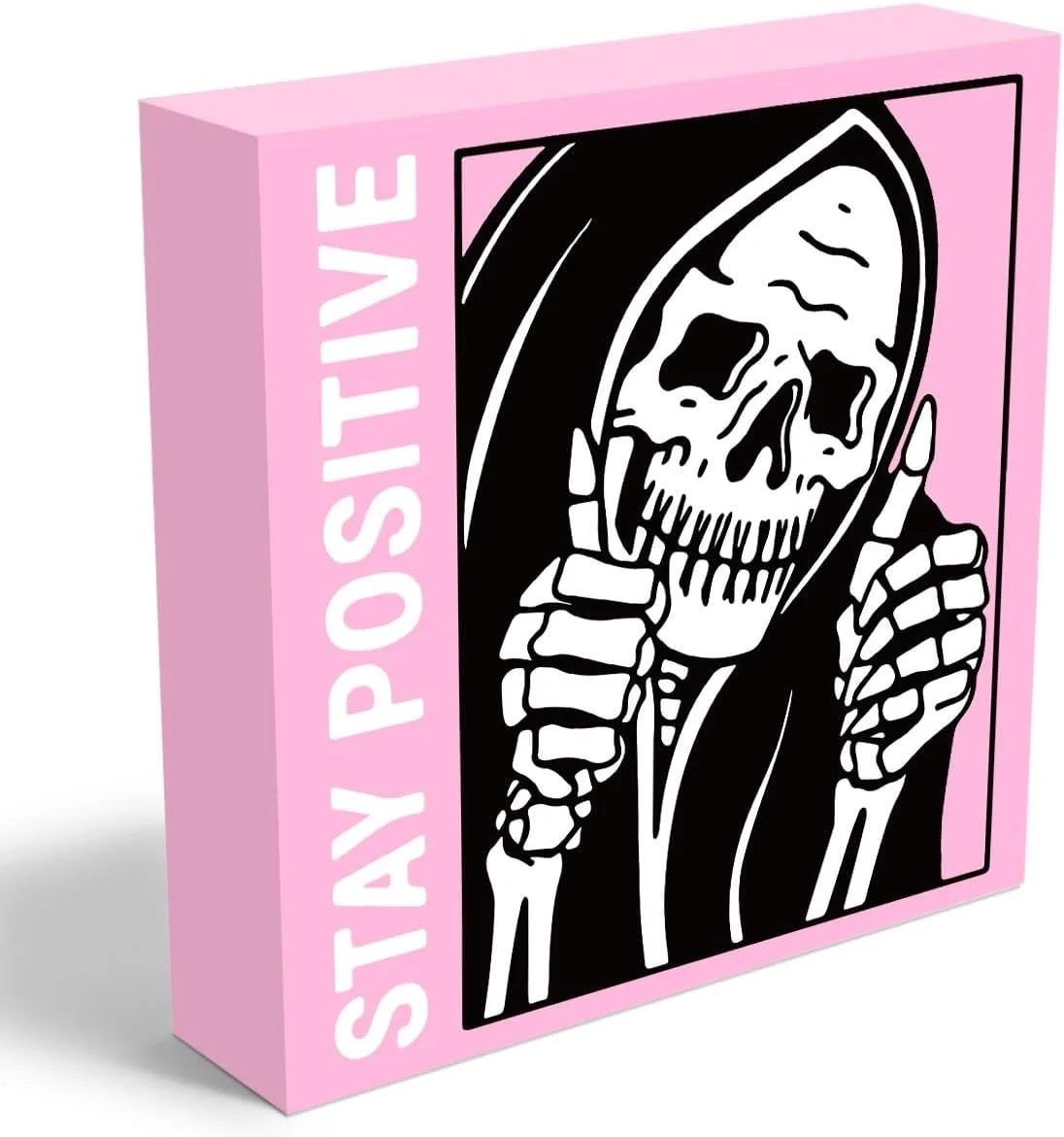 Pink skull and skeleton figure desk sign holding a Stay Positive placard, real product photo